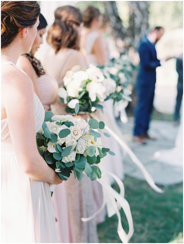 bridesmaids holding beautiful bouquets during wedding ceremony under weeping willow trees at Bridgewater Farm