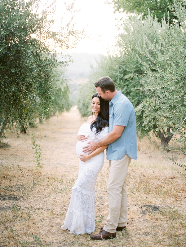 couple embrassing in olive grove in napa