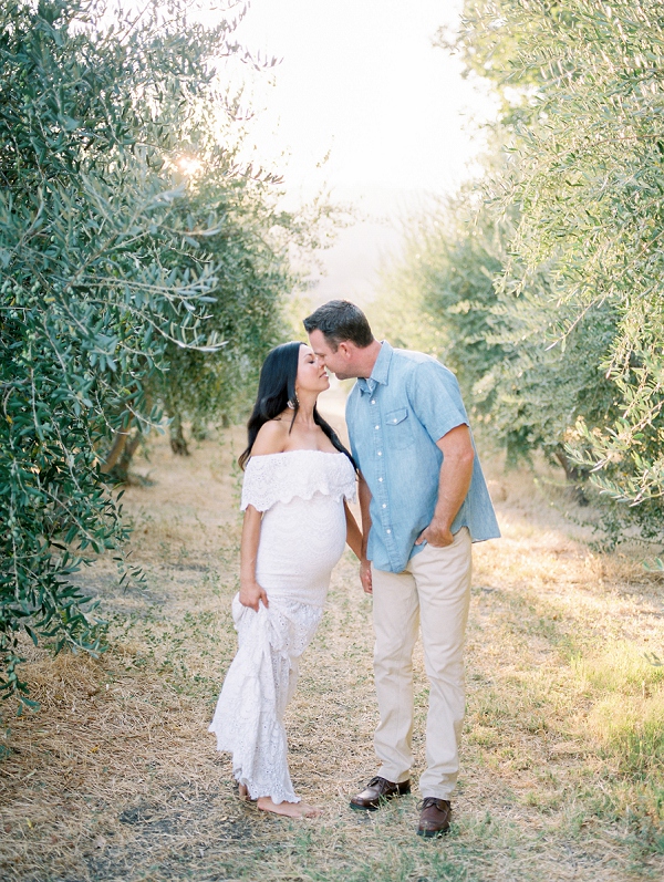 couple kissing in olive grove in napa