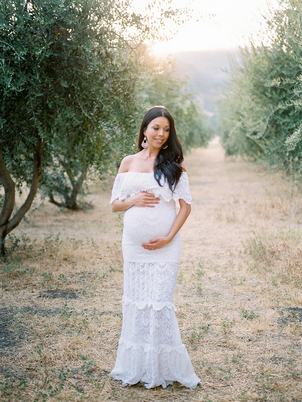 pregnant woman woman holding belly in olive grove in napa
