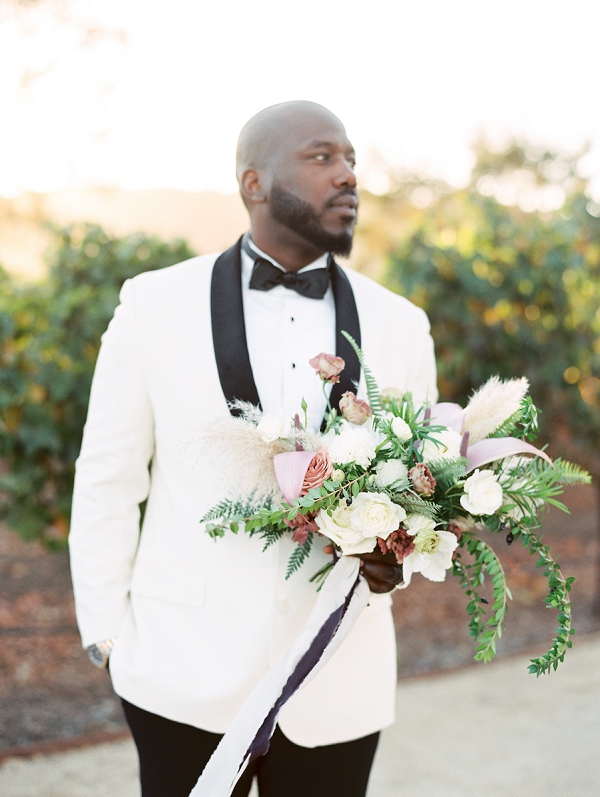 groom holding bouquet