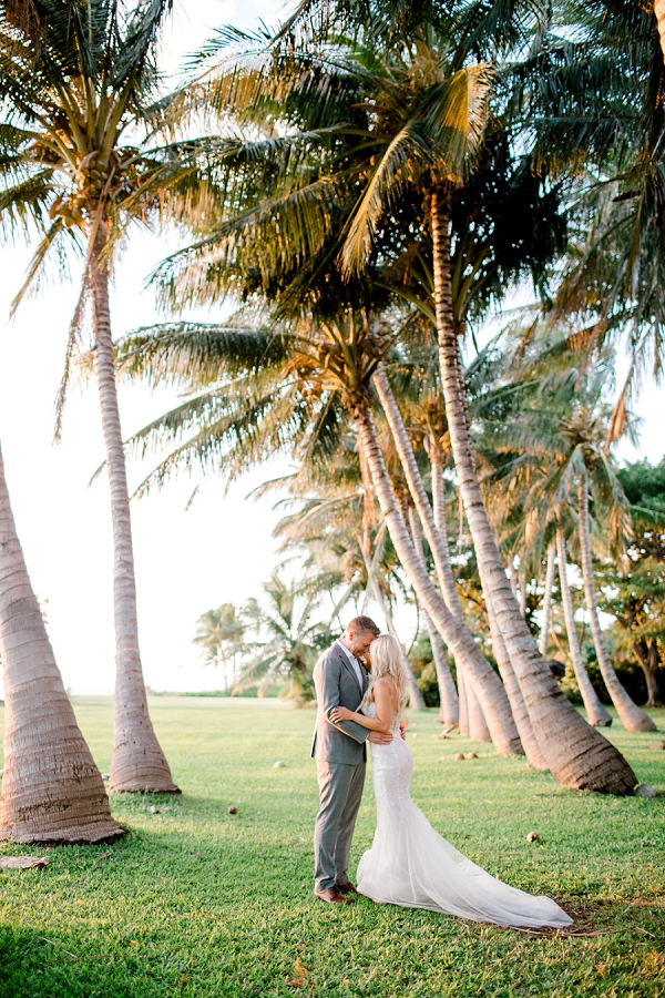 bride and groom kissing among plam trees