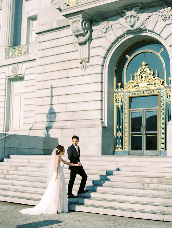 couple holding hands in front of San Francisco city hall for civil ceremony