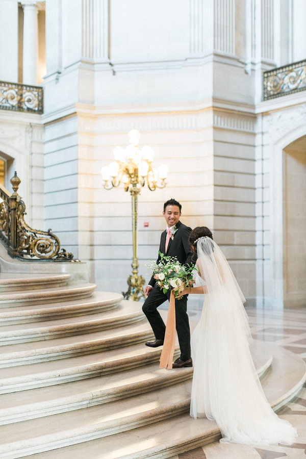couple walking up stairs together at San Francisco city hall