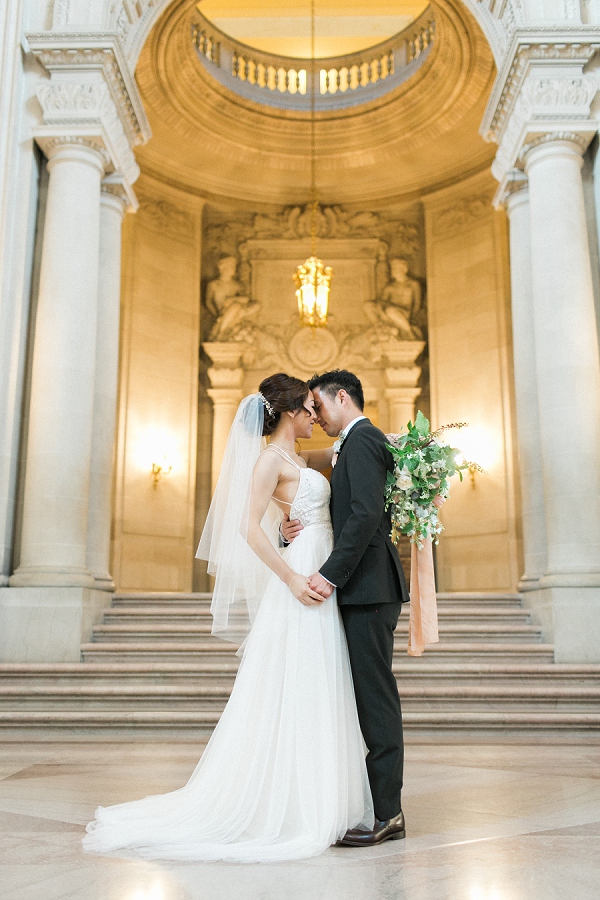 couple embracing on the grand staircase at San Francisco city hall