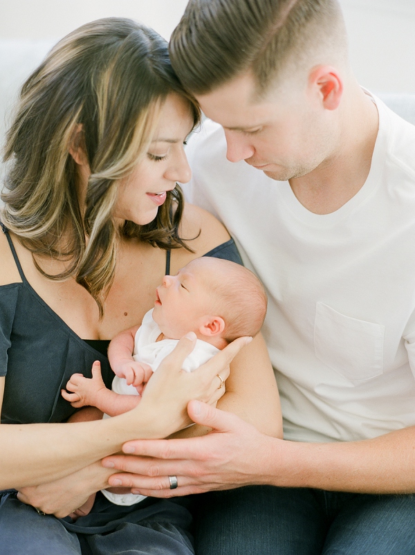 newborn photography session in the Bay Area of California.  Mom and Dad and looking down at newborn baby in their arms.