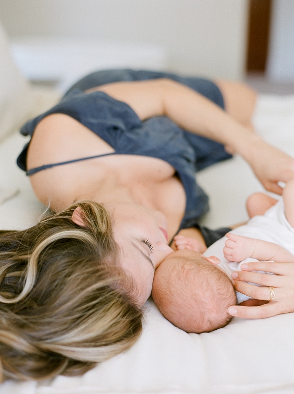 newborn photography San Francisco.  Mom laying on bed cuddling with her newborn baby