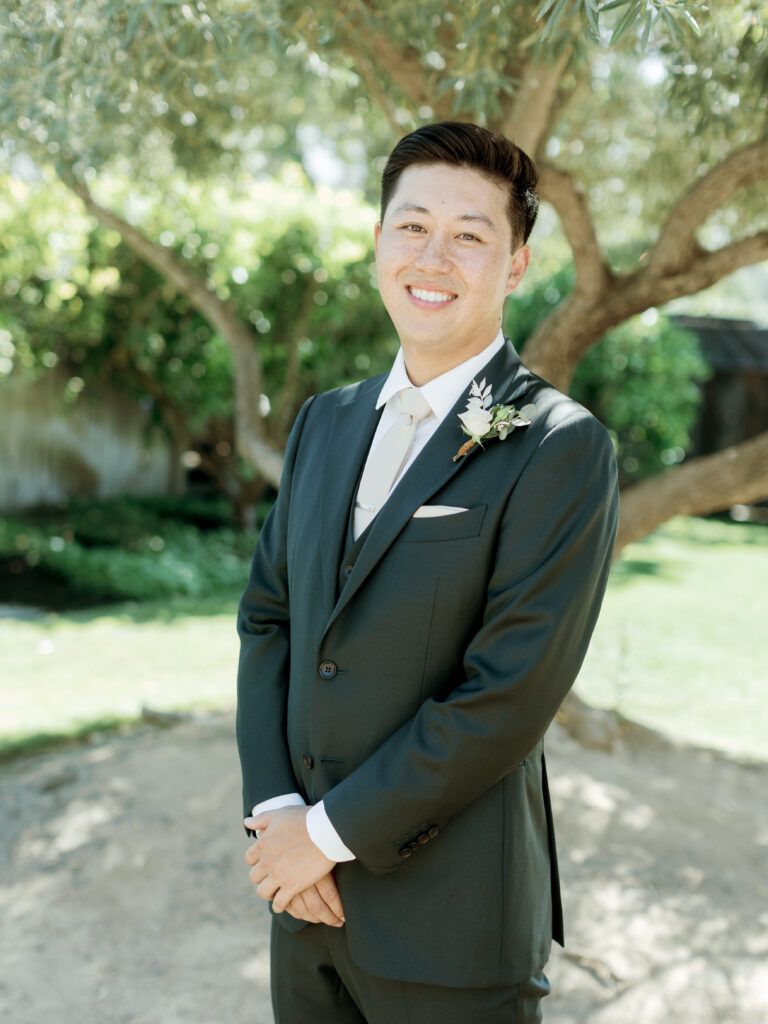 Groom smiling with hands crossed.  Tres Posti Napa Valley Wedding