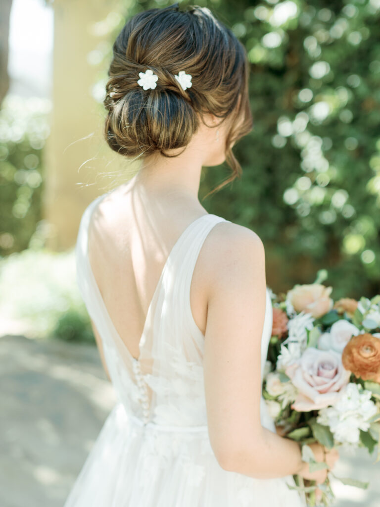 The back of he brides dress and her hair in an elegant chignon. Tres Posti Napa Valley Wedding