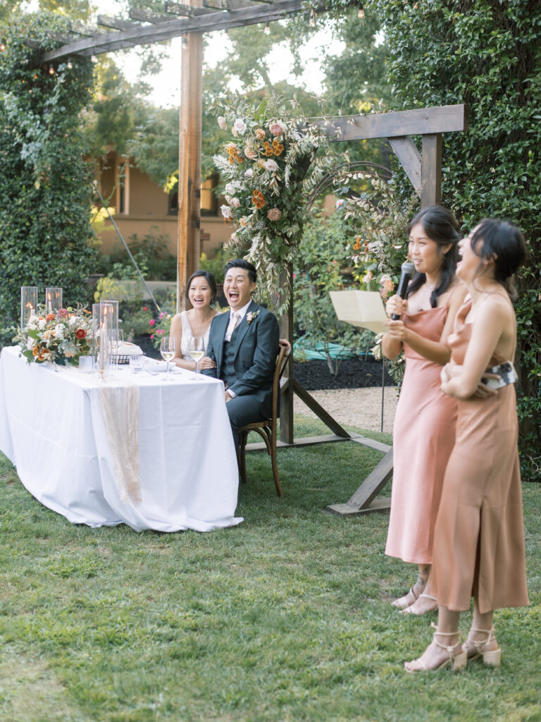 bridesmaids making toasts and the bride and groom smiling. Tres Posti Napa Valley Wedding