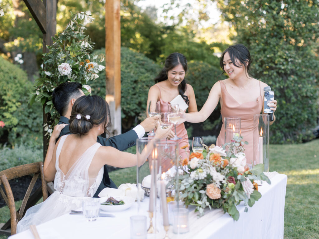 bridesmaids making toasts and the bride and groom laughing. Tres Posti Napa Valley Wedding