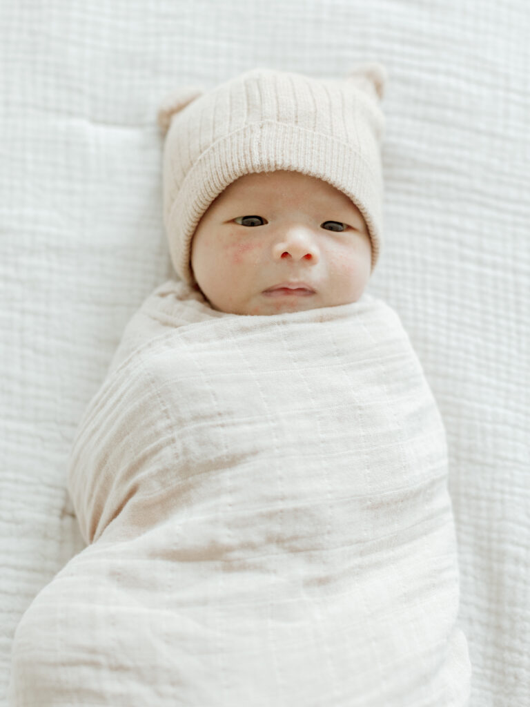 baby swaddled and with a hat for a newborns session