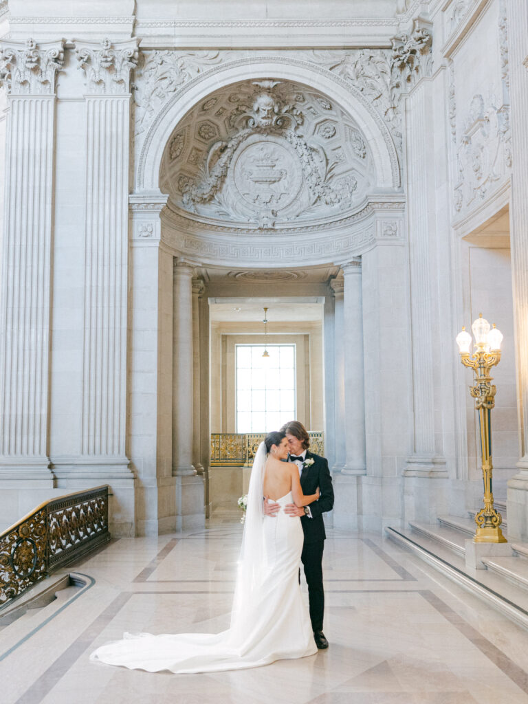 bride and groom posing on the fourth floor galleries in San Francisco City Hall