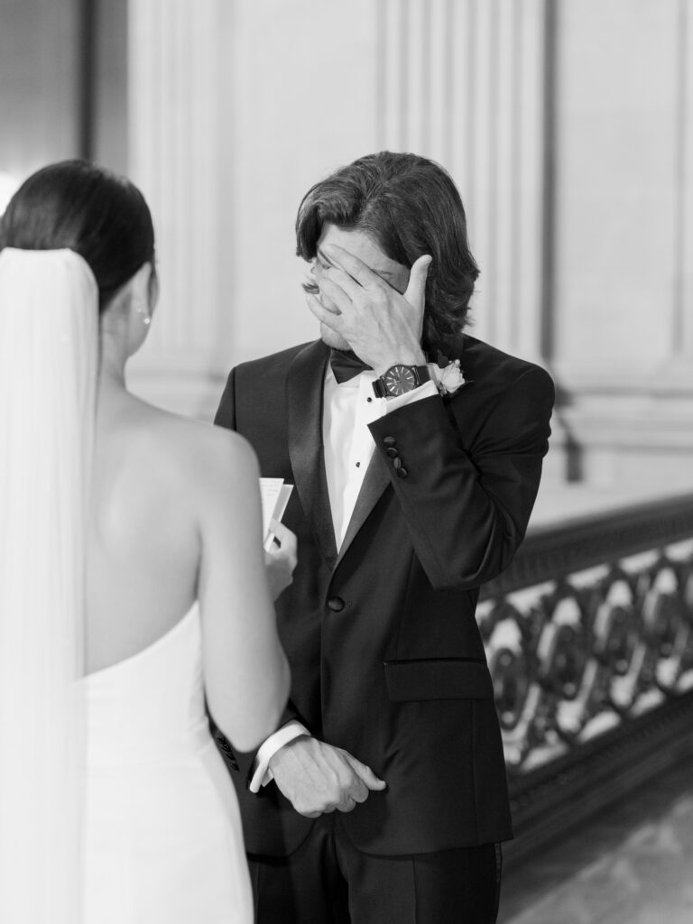 Groom wiping his eyes in black and white