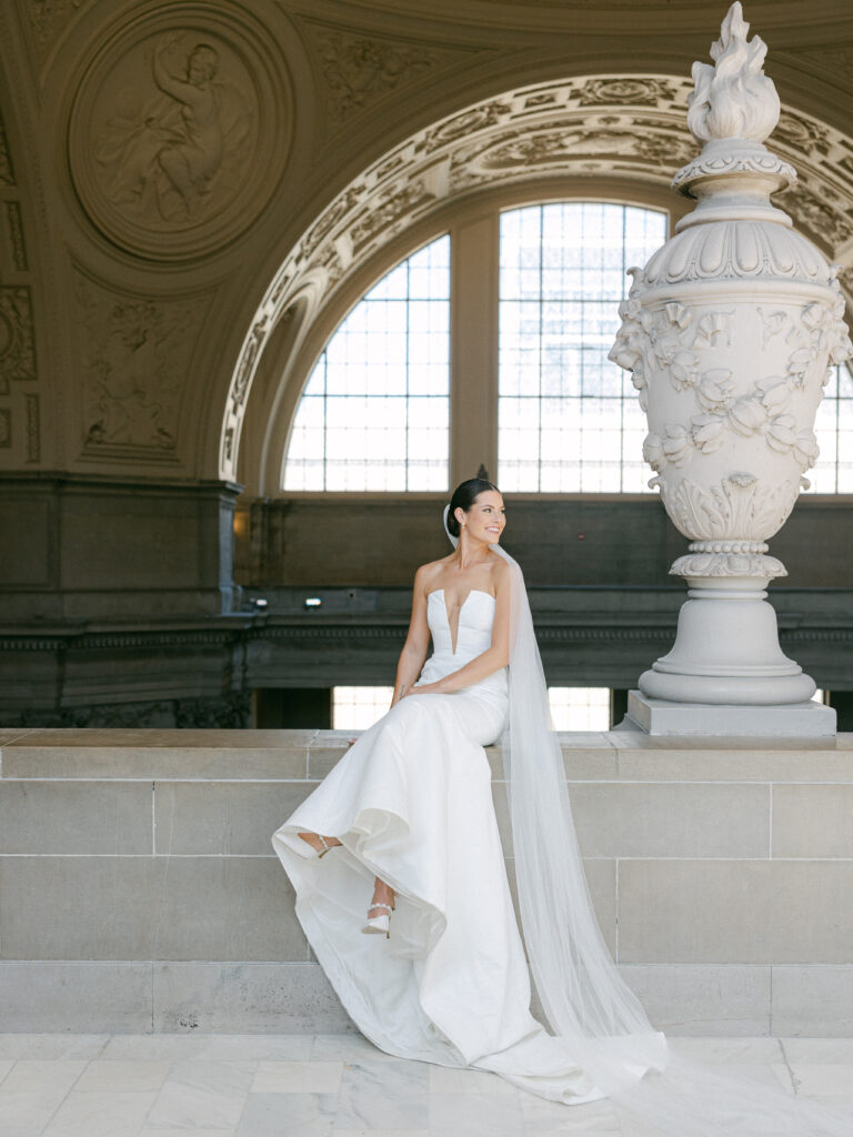 Bride sitting on the ledge of the Fourth Floor Gallery at San Francisco City Hall