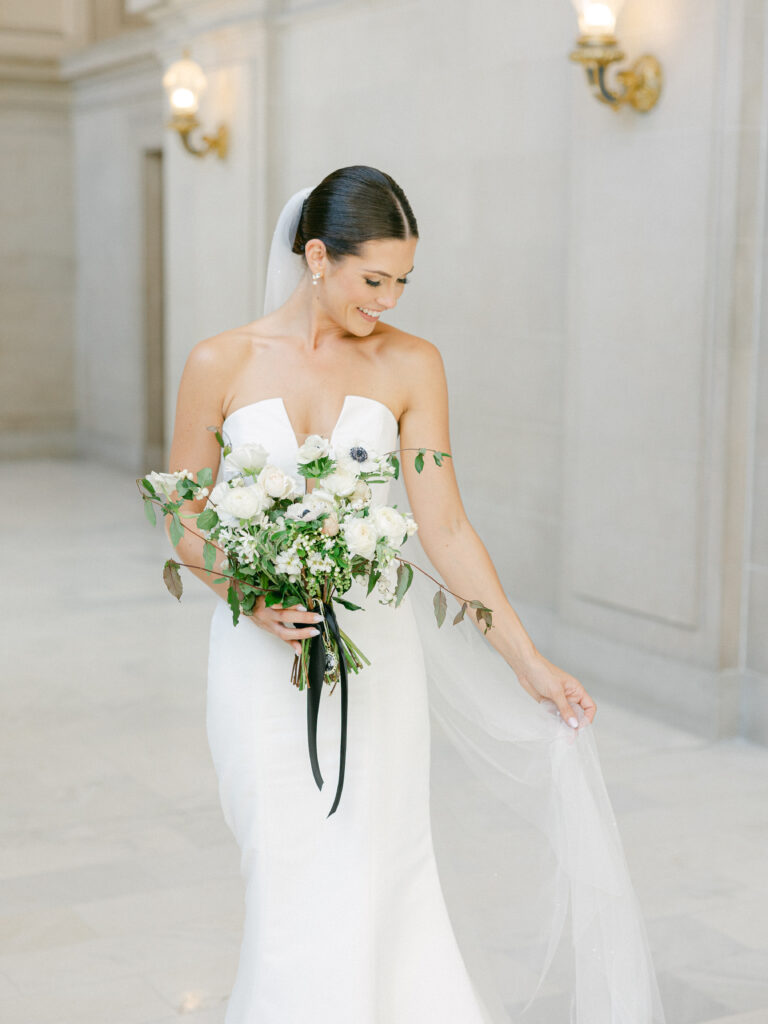 bride holding her veil and bouquet