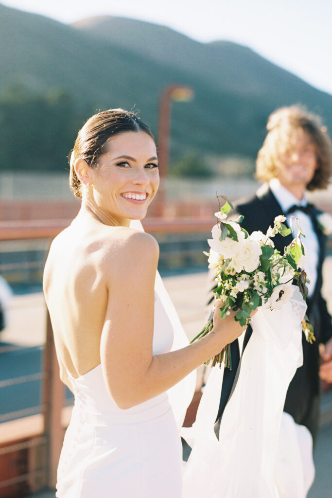 bride smiling at wedding photographer on the golden gate bridge