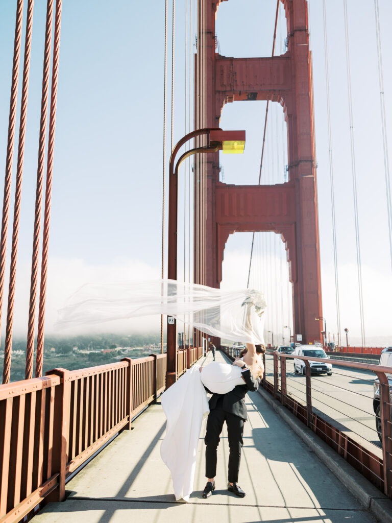 groom carrying bride on the Golden Gate bridge