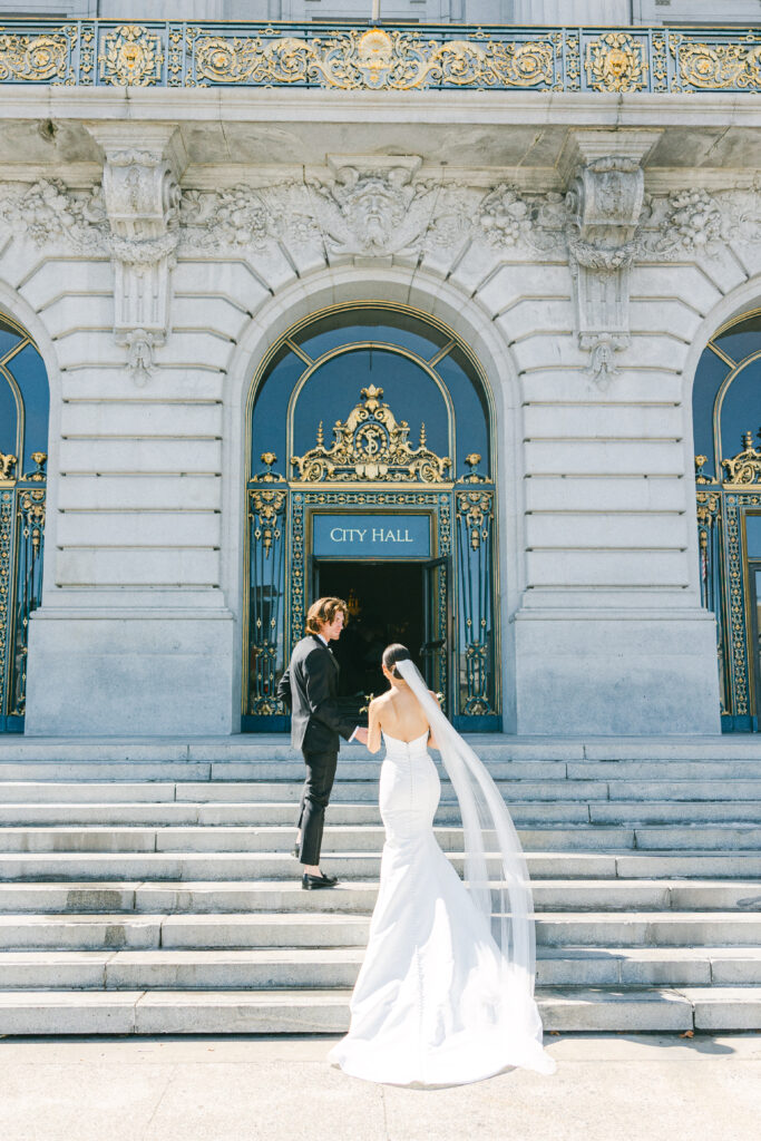 Bride and groom walking into San Francisco City Hall