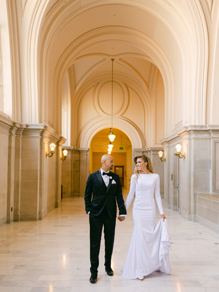 bride and groom walking down the hall in san francisco city hall for their elopement