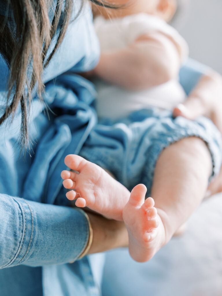 In-Home Newborn Session near San Francisco.  Mother holding baby and the focus is on the baby's feet.